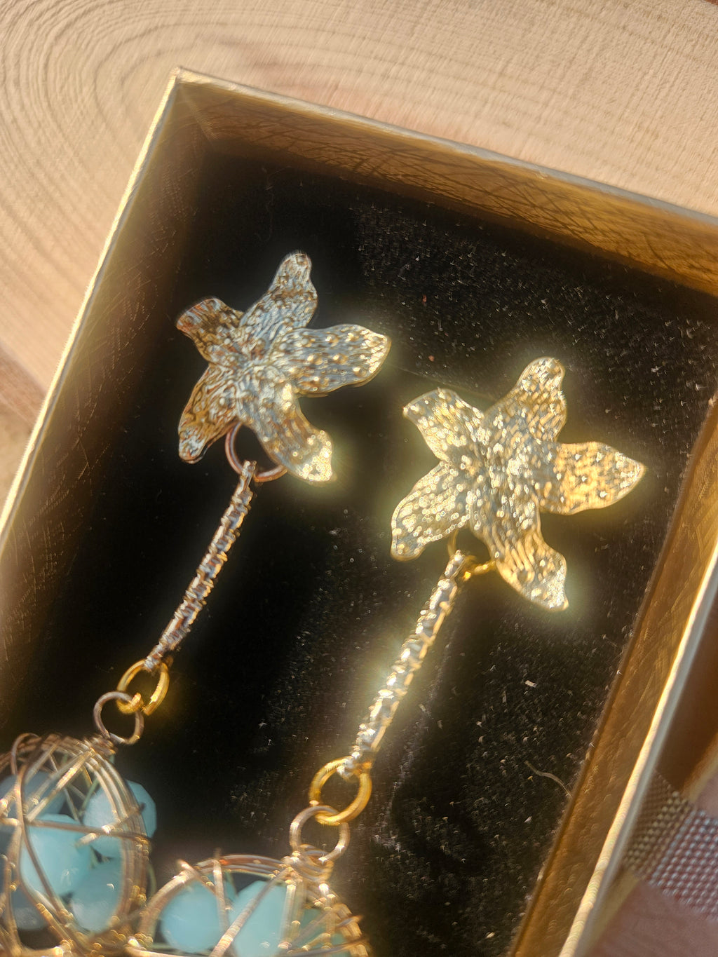 Pendientes Caspio con dijes florales dorados y cuentas esféricas azules enrejadas