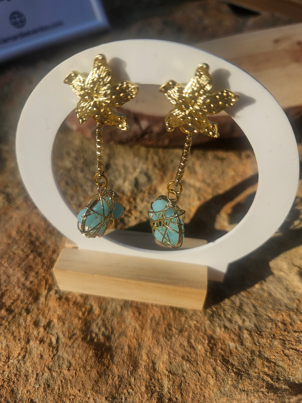 Pendientes Caspio dorados con dijes florales y cuentas esféricas azules enrejadas