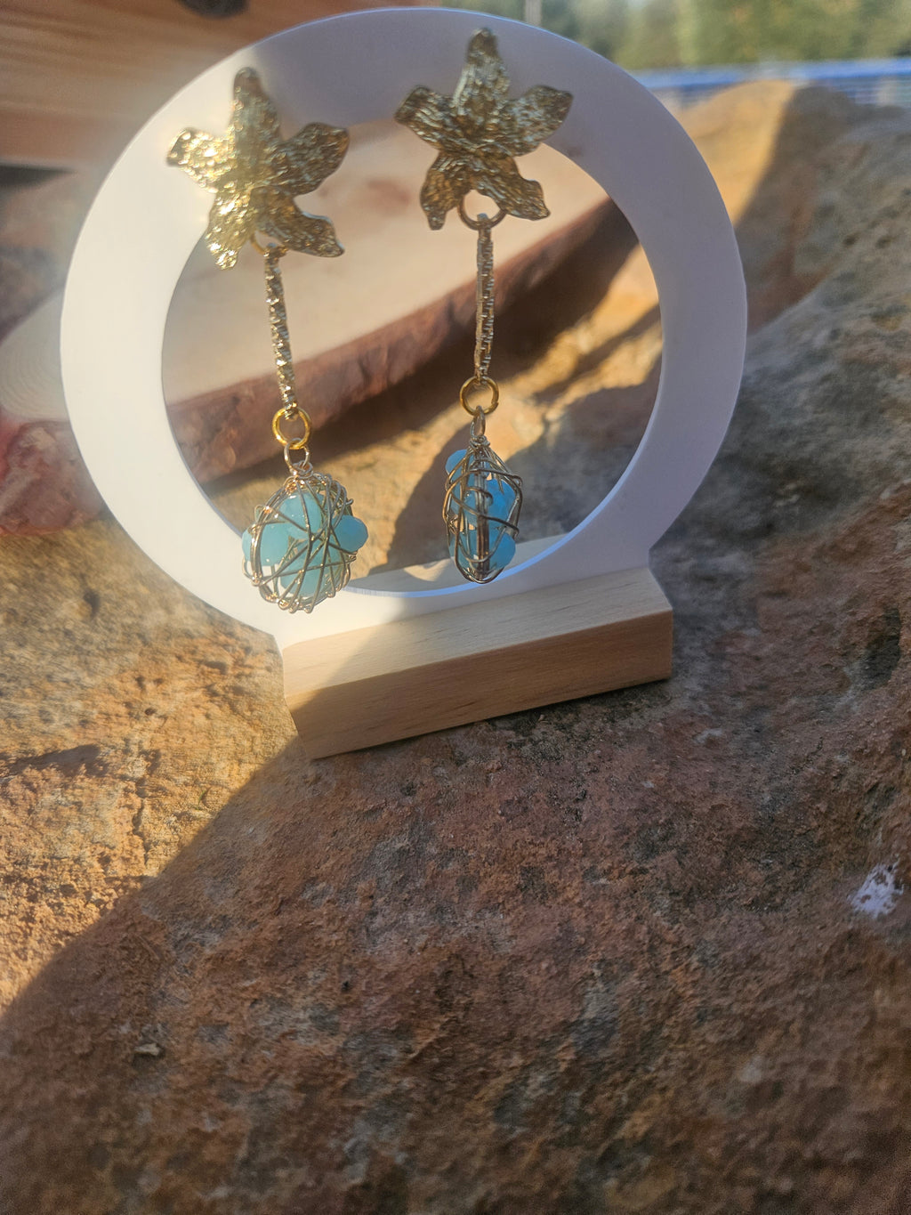 Pendientes Caspio con dijes florales dorados y esferas azules enrejadas colgantes