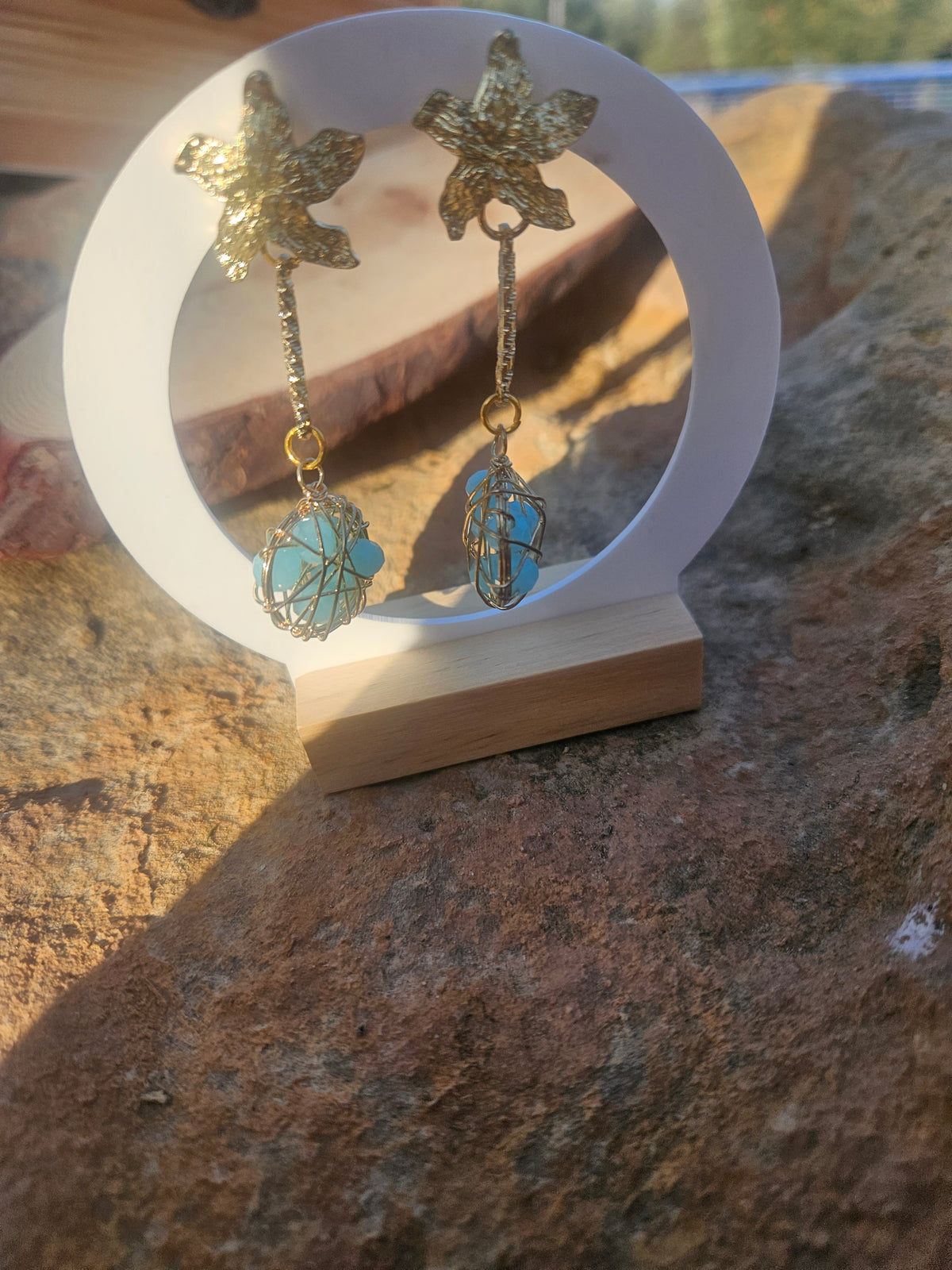 Pendientes Caspio con dijes florales dorados y esferas azules enrejadas colgantes