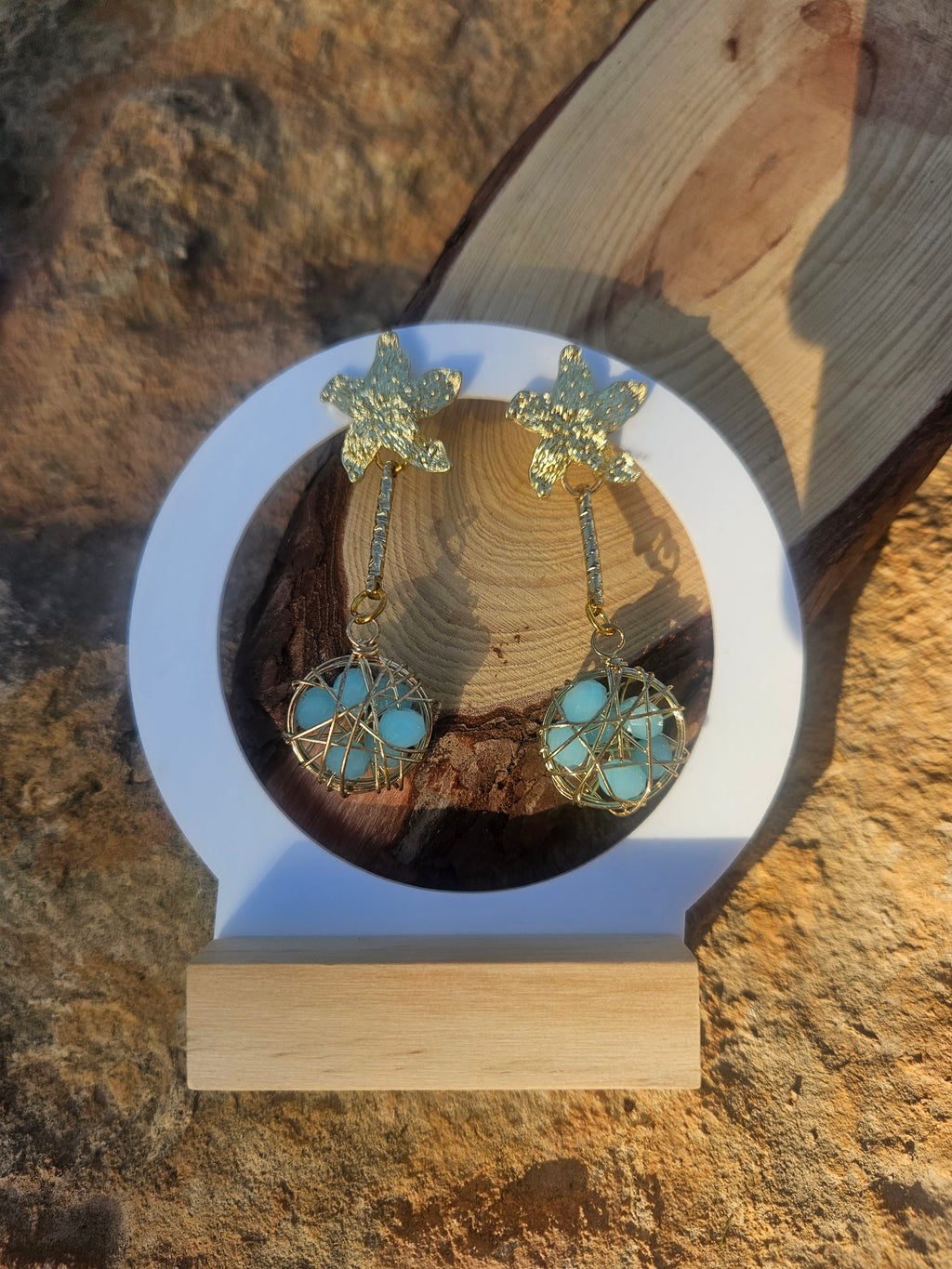 Pendientes Caspio con dijes florales dorados y esferas azules enrejadas colgantes