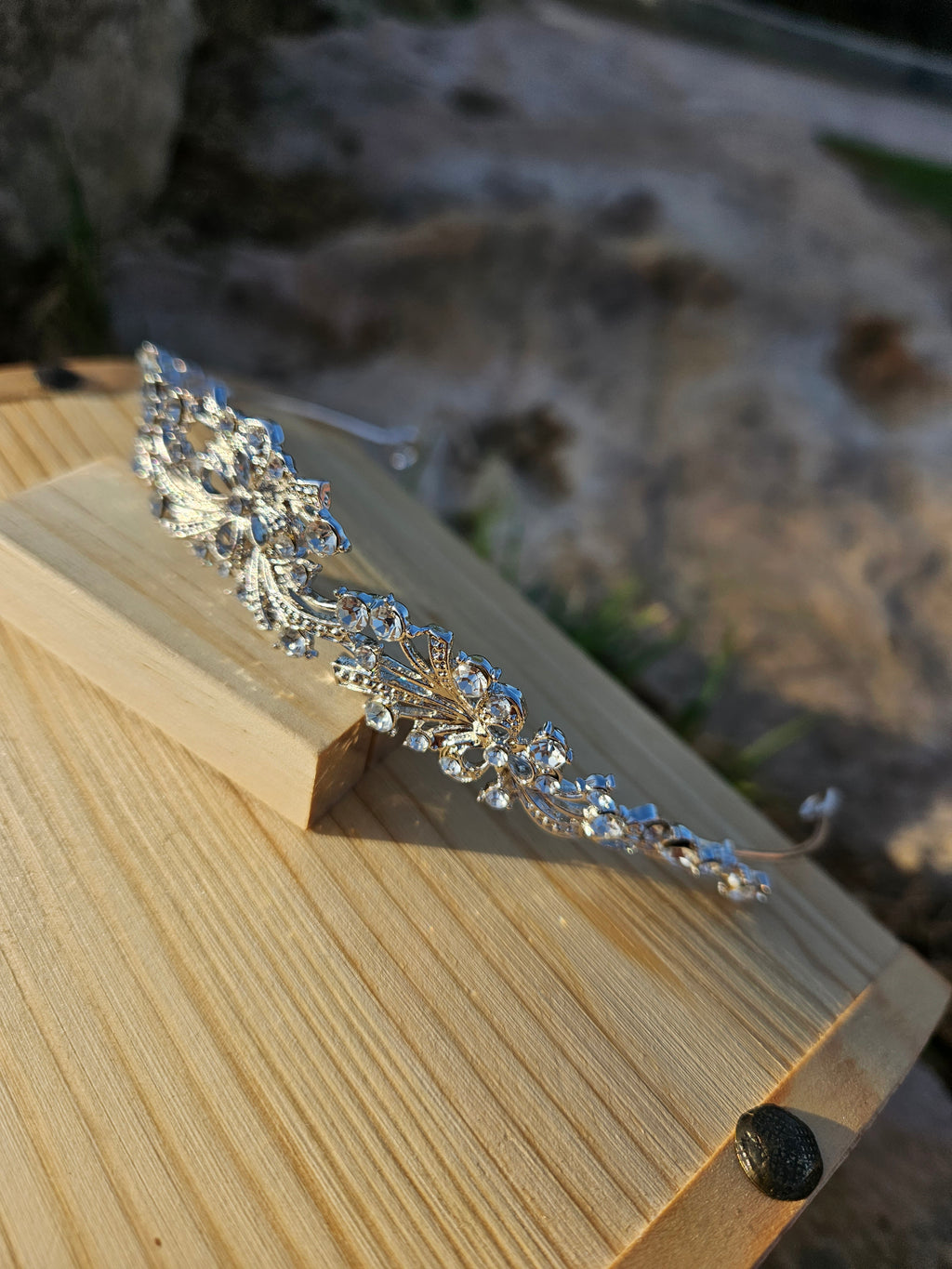 Corona de novia plateada con pedrería, diseño ondulado y cintas decorativas