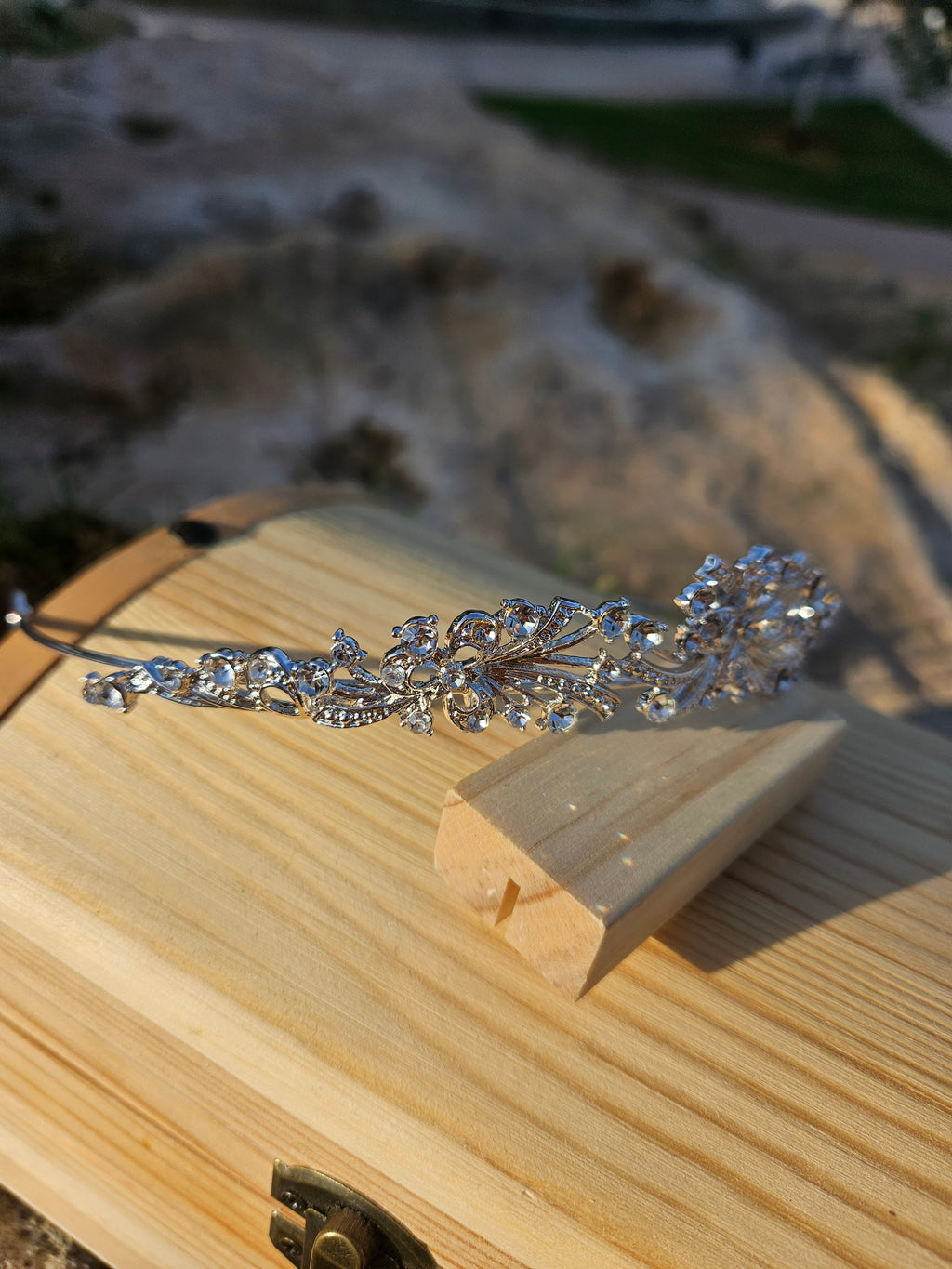 Corona de novia plateada con pedrería y nudo central, estilo ornamental