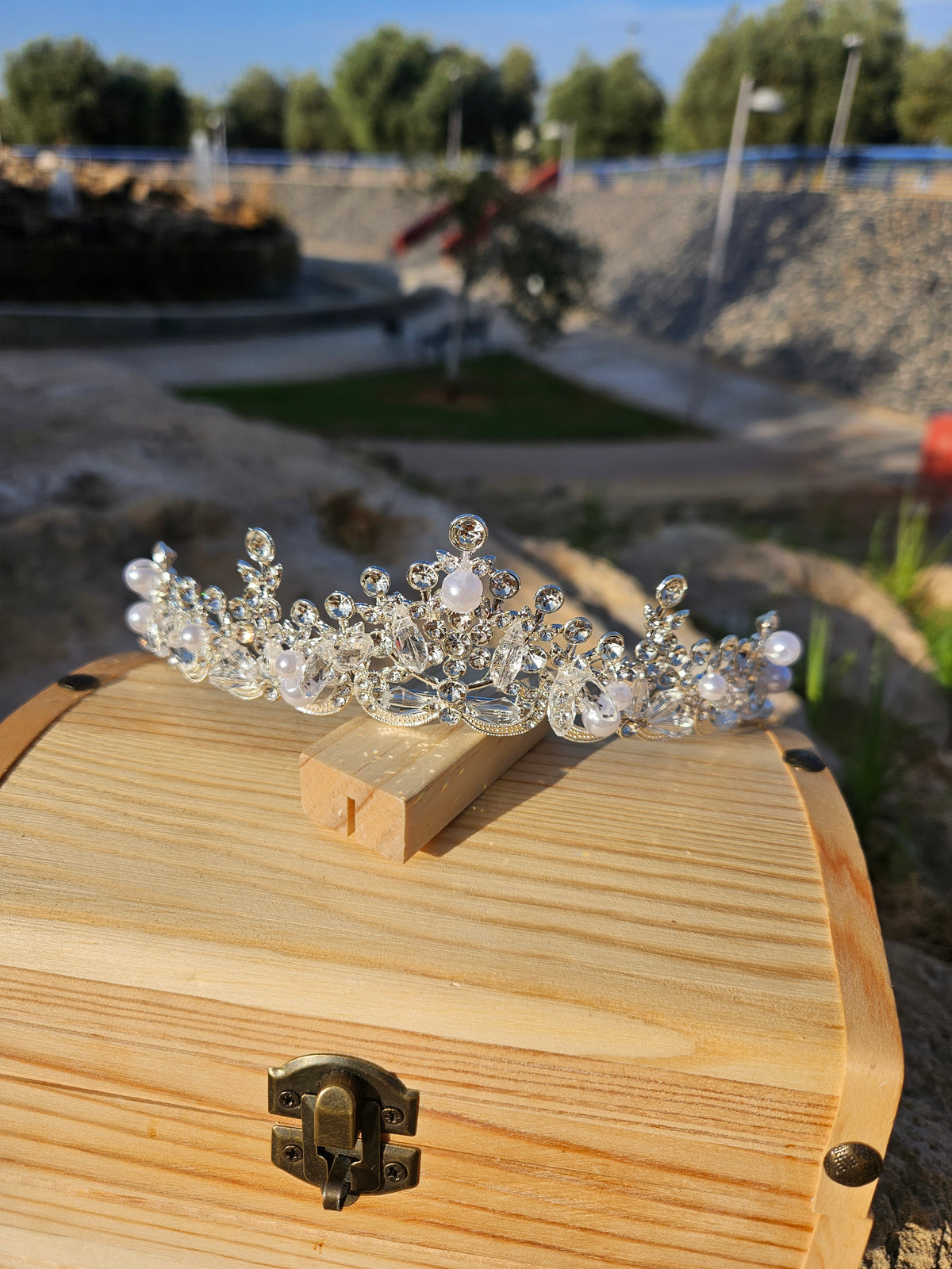Corona de novia Fátima plateada con pedrería y perlas, sobre base de madera