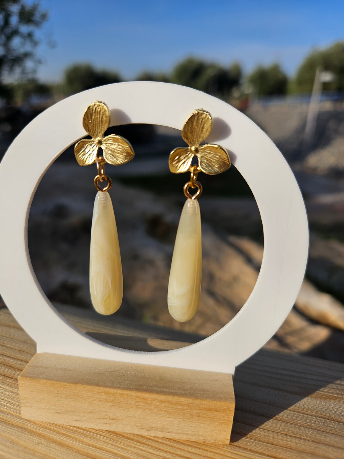 Pendientes colgantes: flores doradas con gota marfil, vista frontal