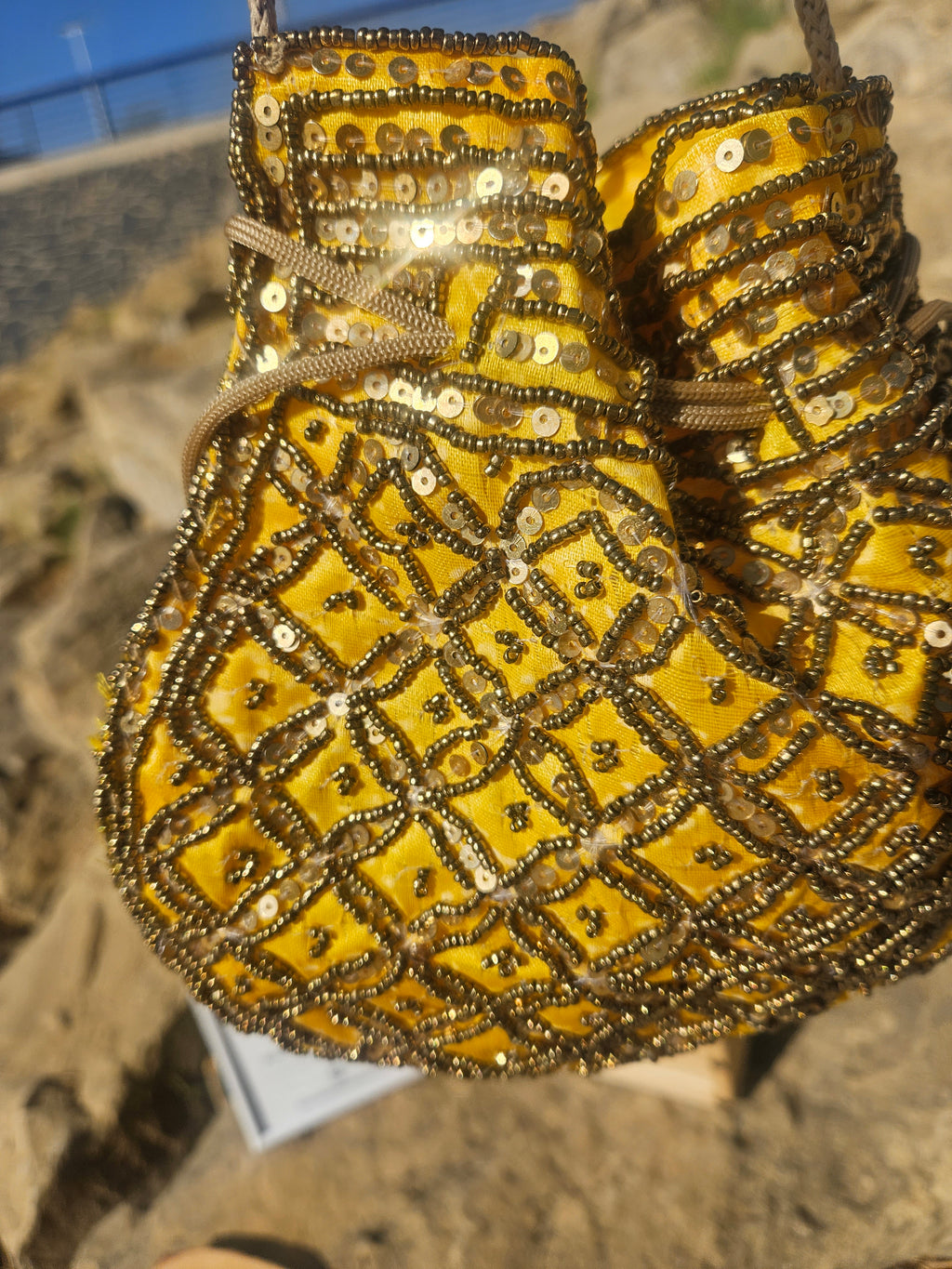 Bolso de tela amarillo decorado con lentejuelas y cuentas en patrón geométrico