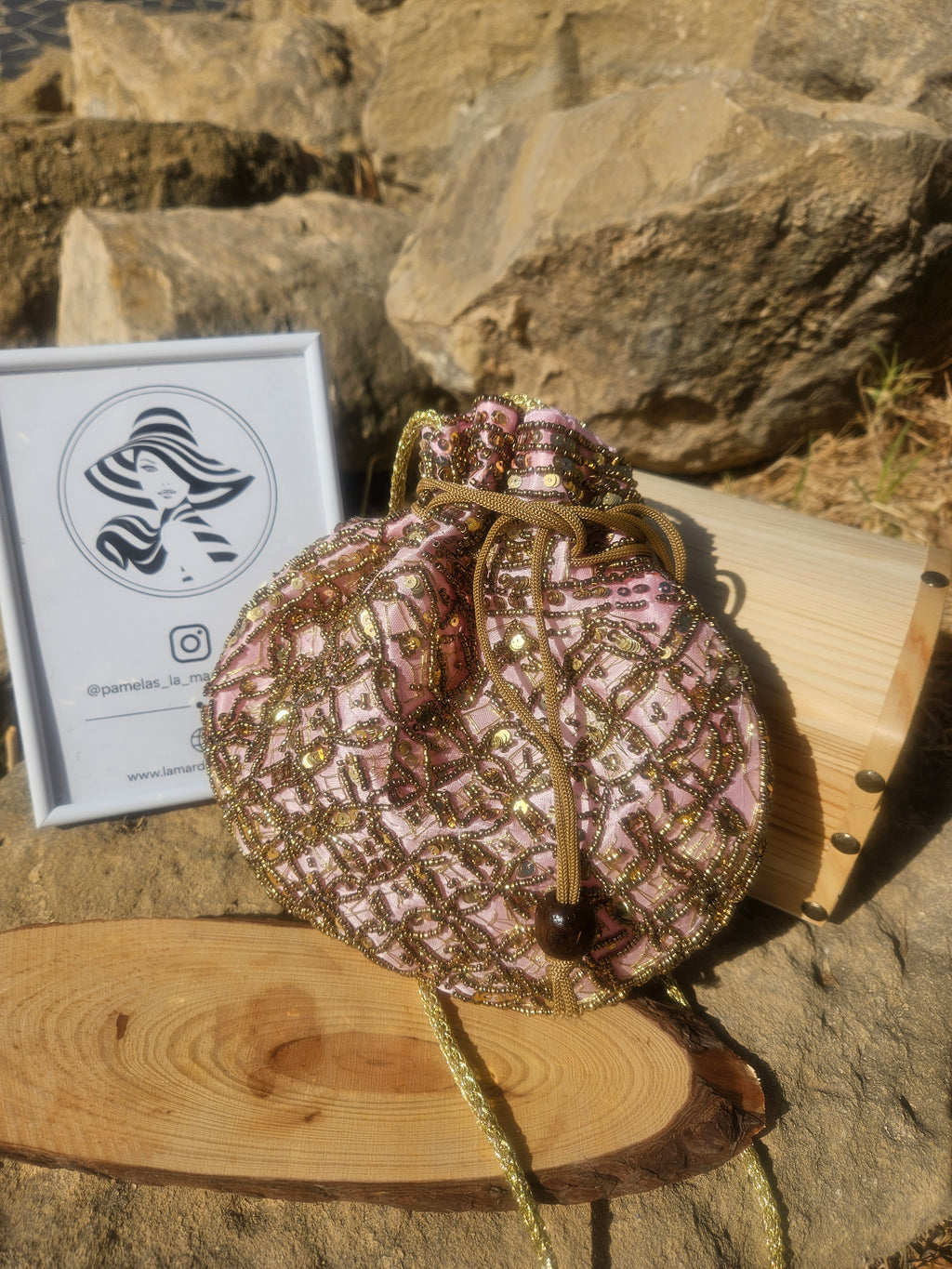 Bolso saco de lentejuelas rosa y dorado, cierre con cordón y asa trenzada