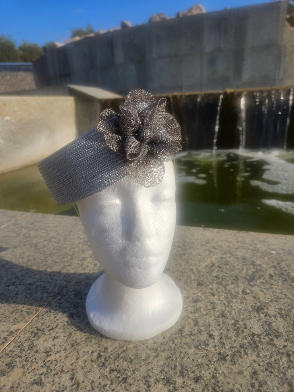 Sombrero casquete gris con cinta ondulada y flor de tul en el lateral
