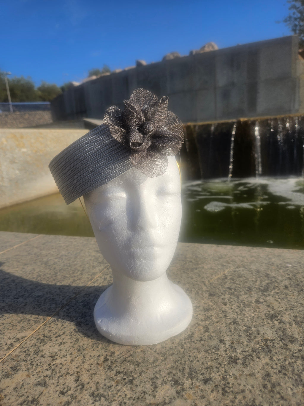 Sombrero casquete gris con flor de tul grande y cinta texturizada en el lateral