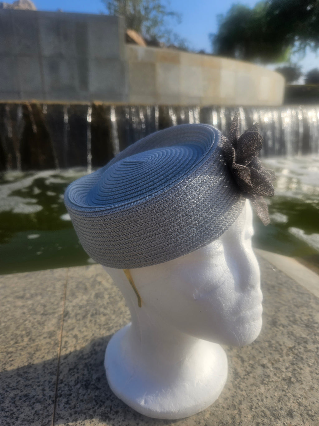 Sombrero casquete azul claro con ala corta y flor de tul negra en la copa