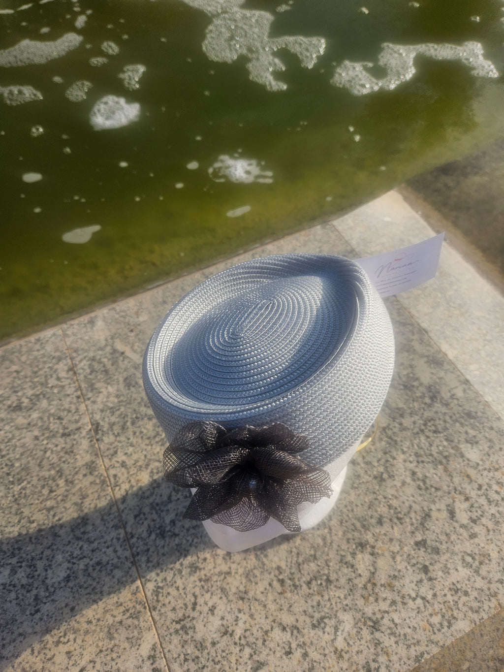 Sombrero casquete azul claro visto desde arriba con flor de tul en un lado