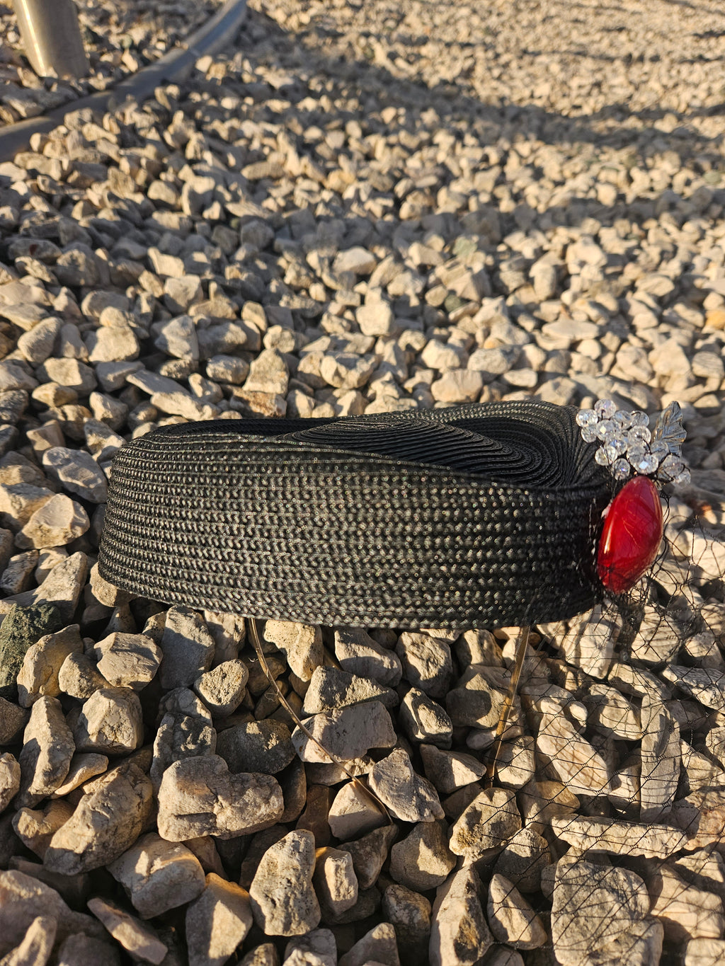 Sombrero casquete negro con adorno rojo y flores plateadas, perfil