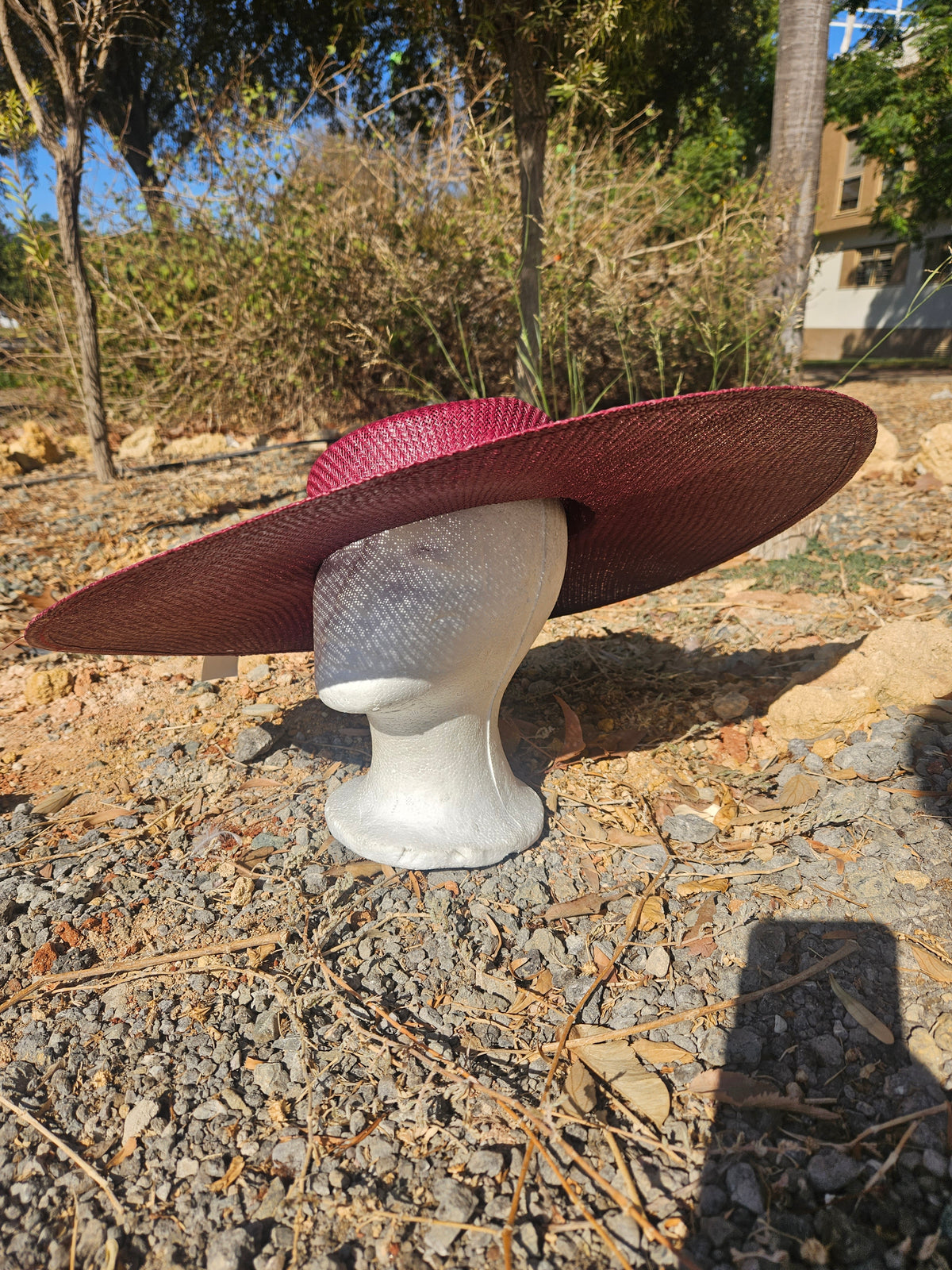 Sombrero burdeos de ala ancha con banda oscura, vista lateral y copa entera