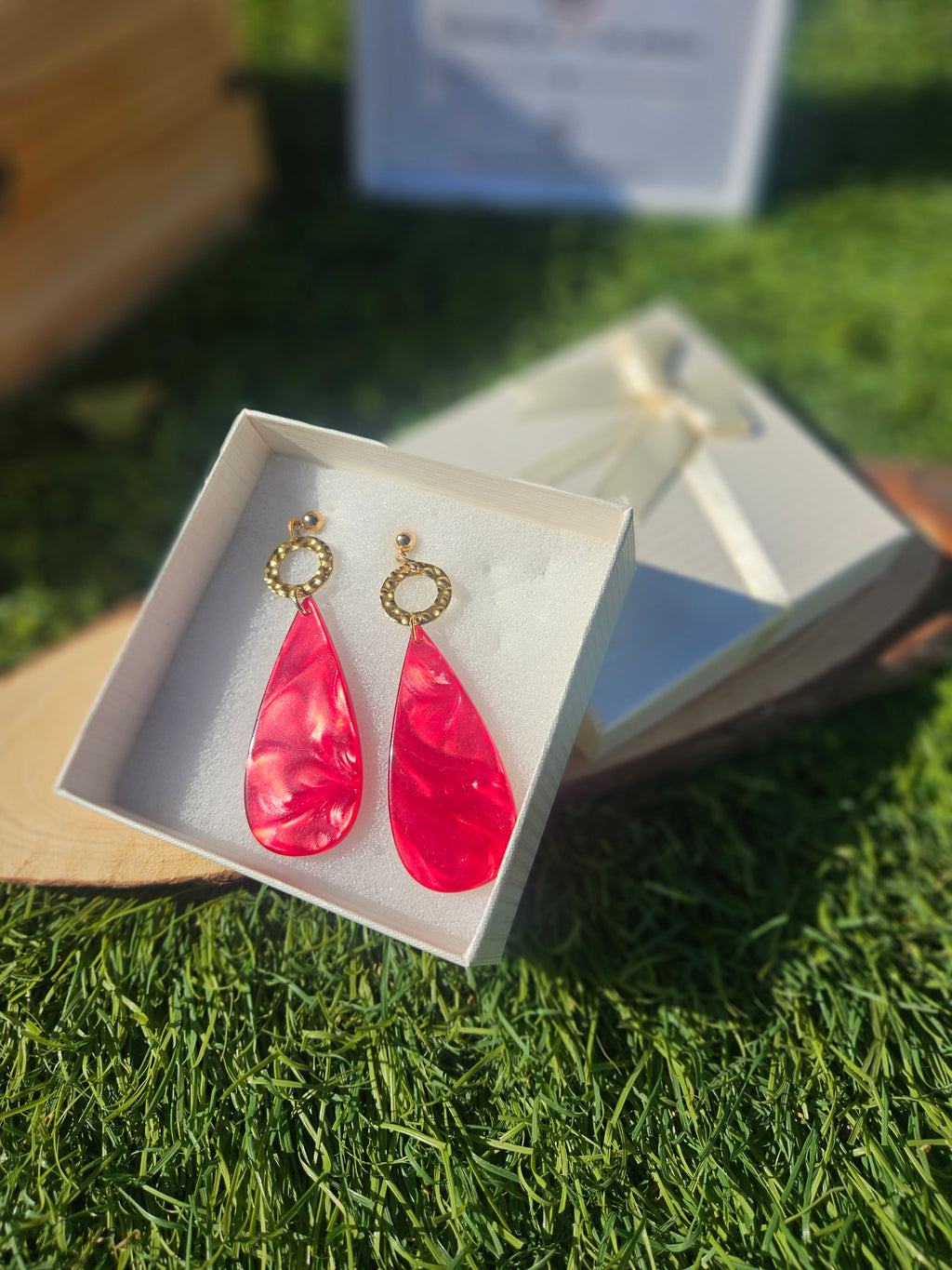 Pendientes con gotas rojas brillantes y argollas doradas decoradas