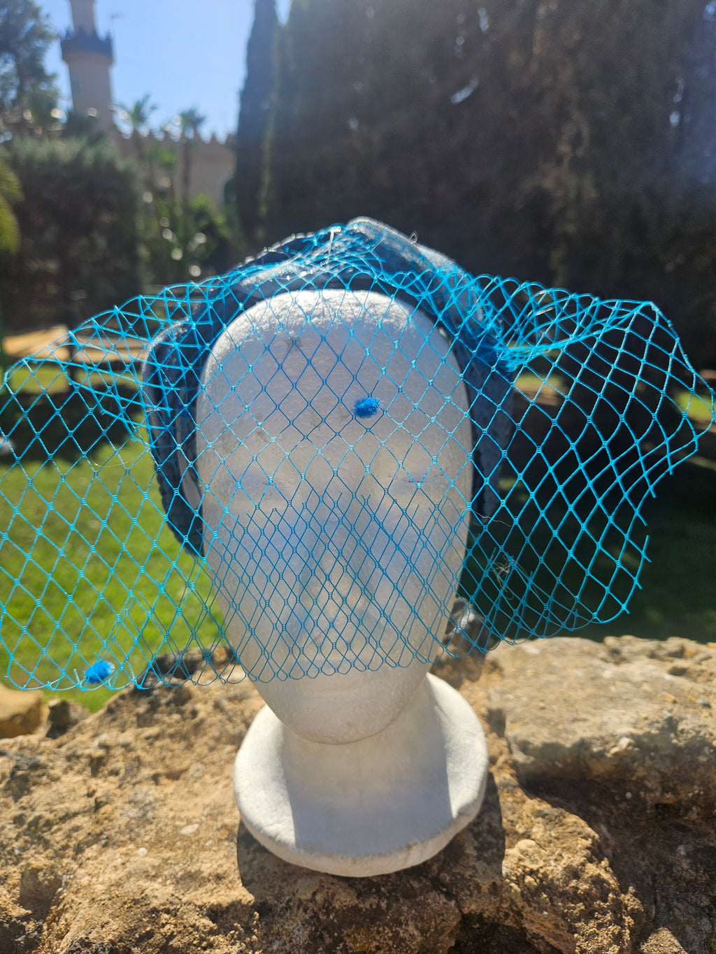 Diadema Águeda azul con velo de malla, frontal sobre soporte