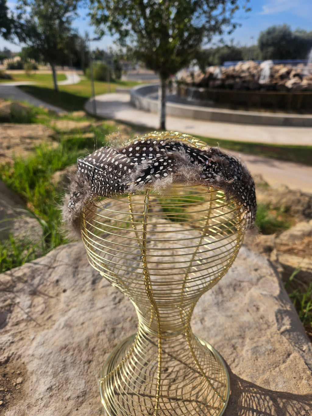 Diadema de malla dorada con banda de plumas negras con cuentas blancas