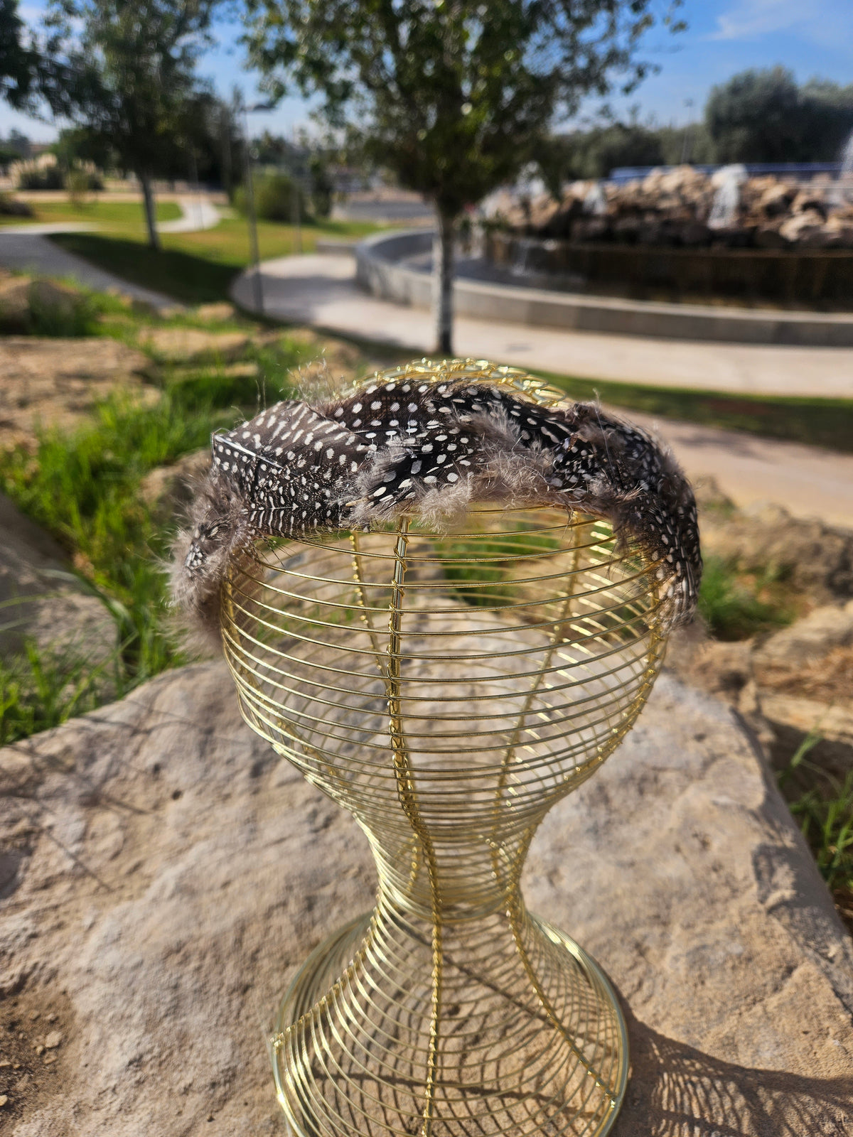 Diadema de malla dorada con banda de plumas negras con cuentas blancas