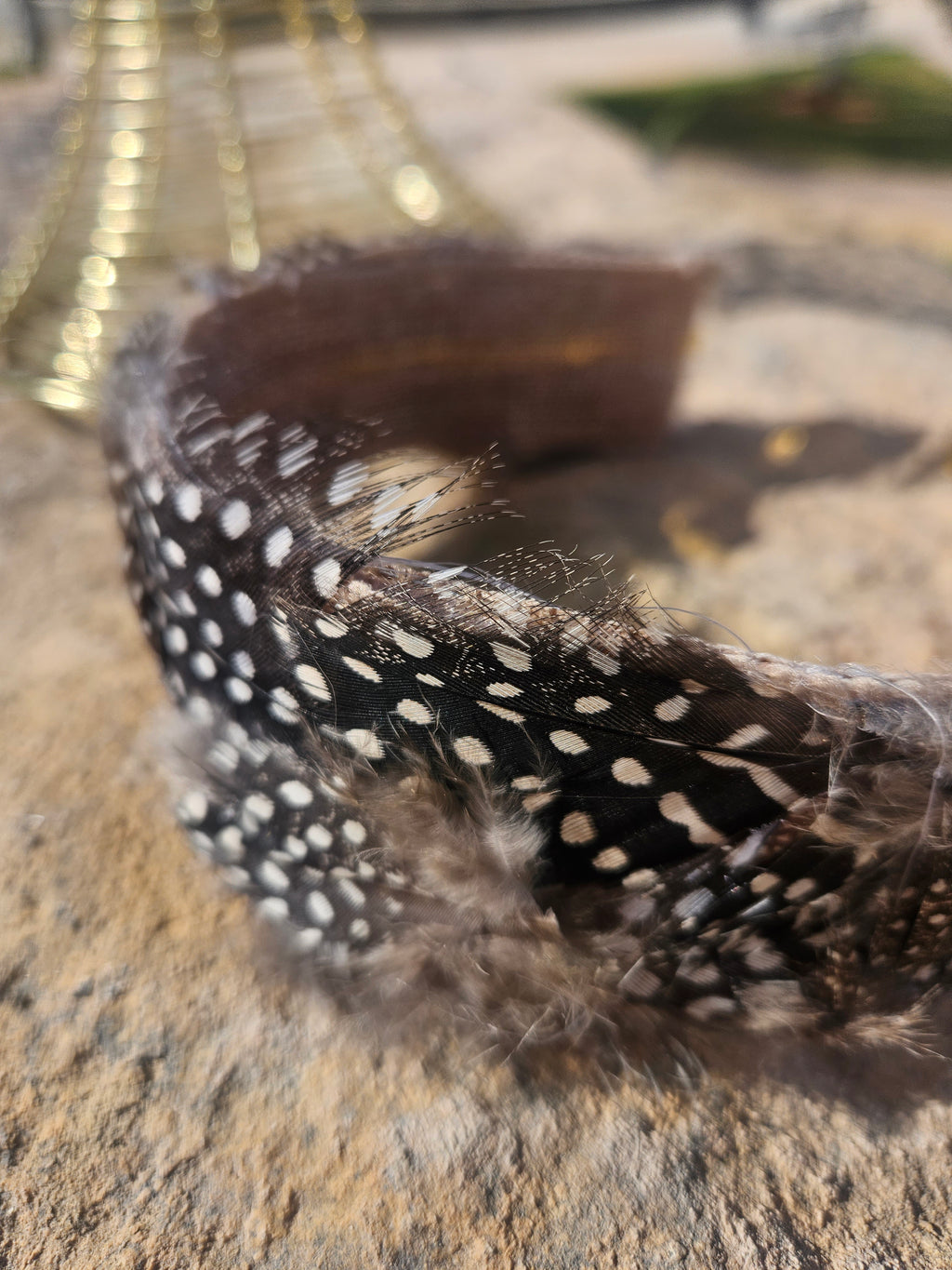 Diadema con banda negra de plumas con cuentas blancas y textura esponjosa