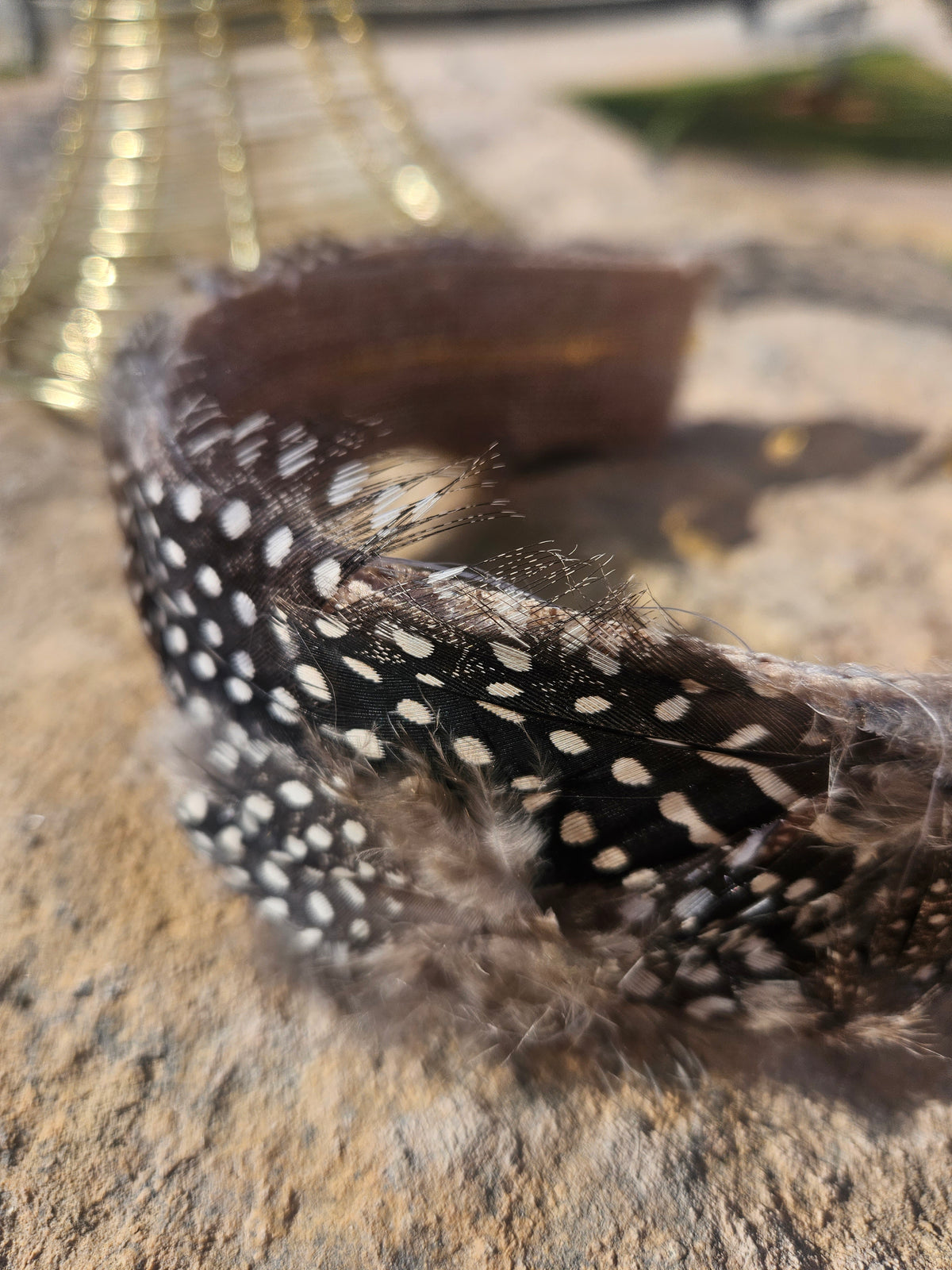 Diadema con banda negra de plumas con cuentas blancas y textura esponjosa