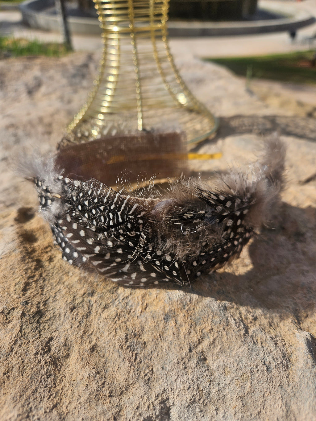 Diadema de malla dorada con banda negra de plumas con cuentas blancas