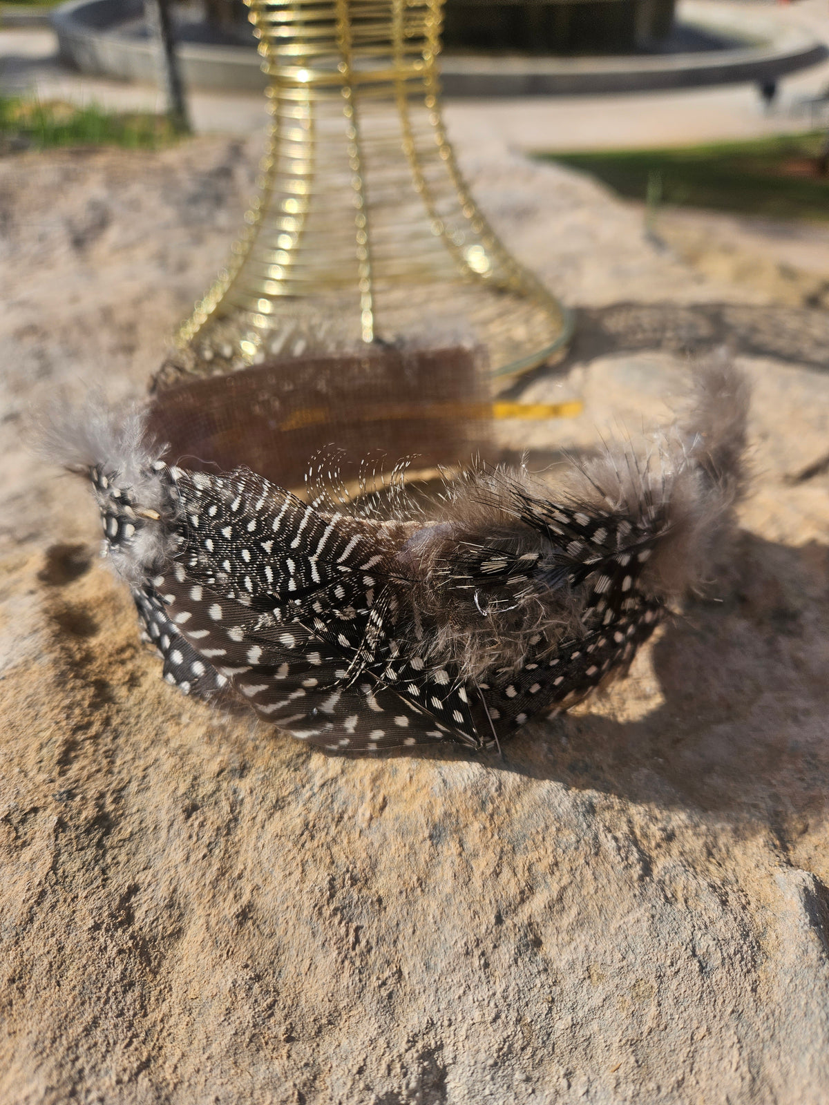 Diadema de malla dorada con banda negra de plumas con cuentas blancas