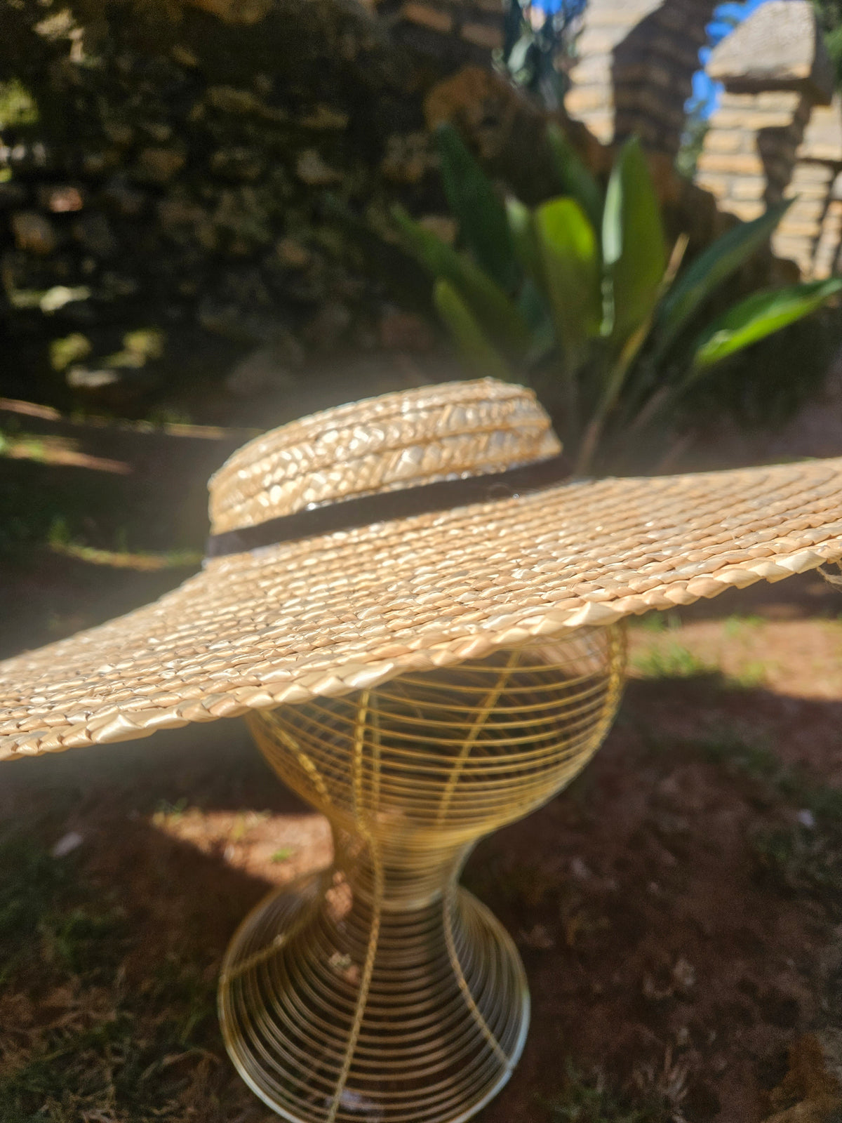 Sombrero de paja estilo panamá con ala ancha y cinta negra, vista lateral
