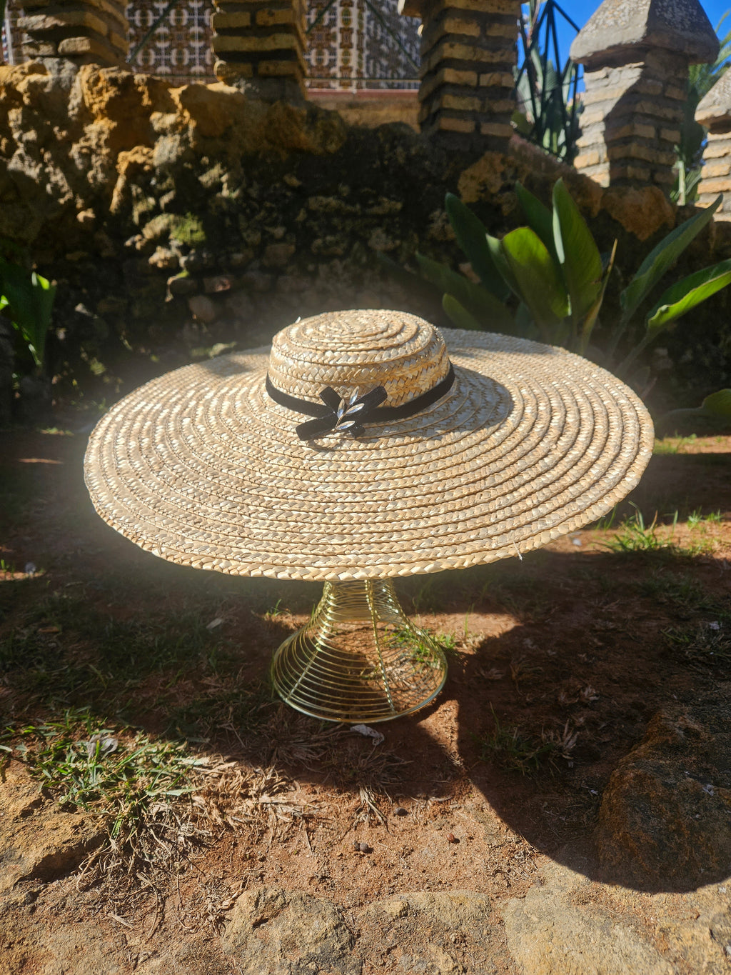 Sombrero de paja estilo panamá con ala ancha y cinta negra, vista trasera