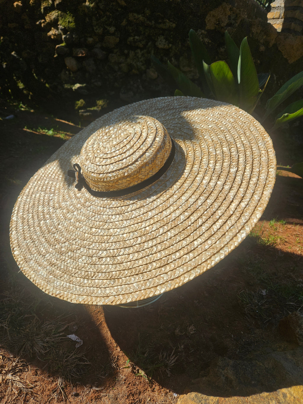 Sombrero de paja estilo panamá con ala ancha y cinta negra, vista en ángulo