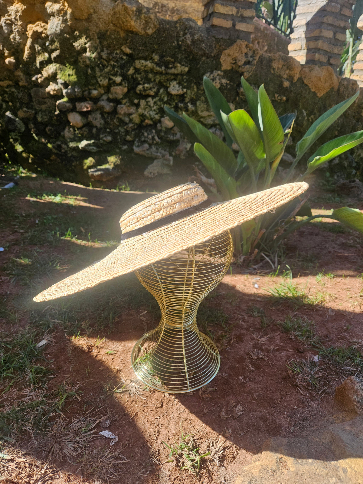 Sombrero de paja estilo panamá con ala ancha y cinta negra, vista lateral amplia