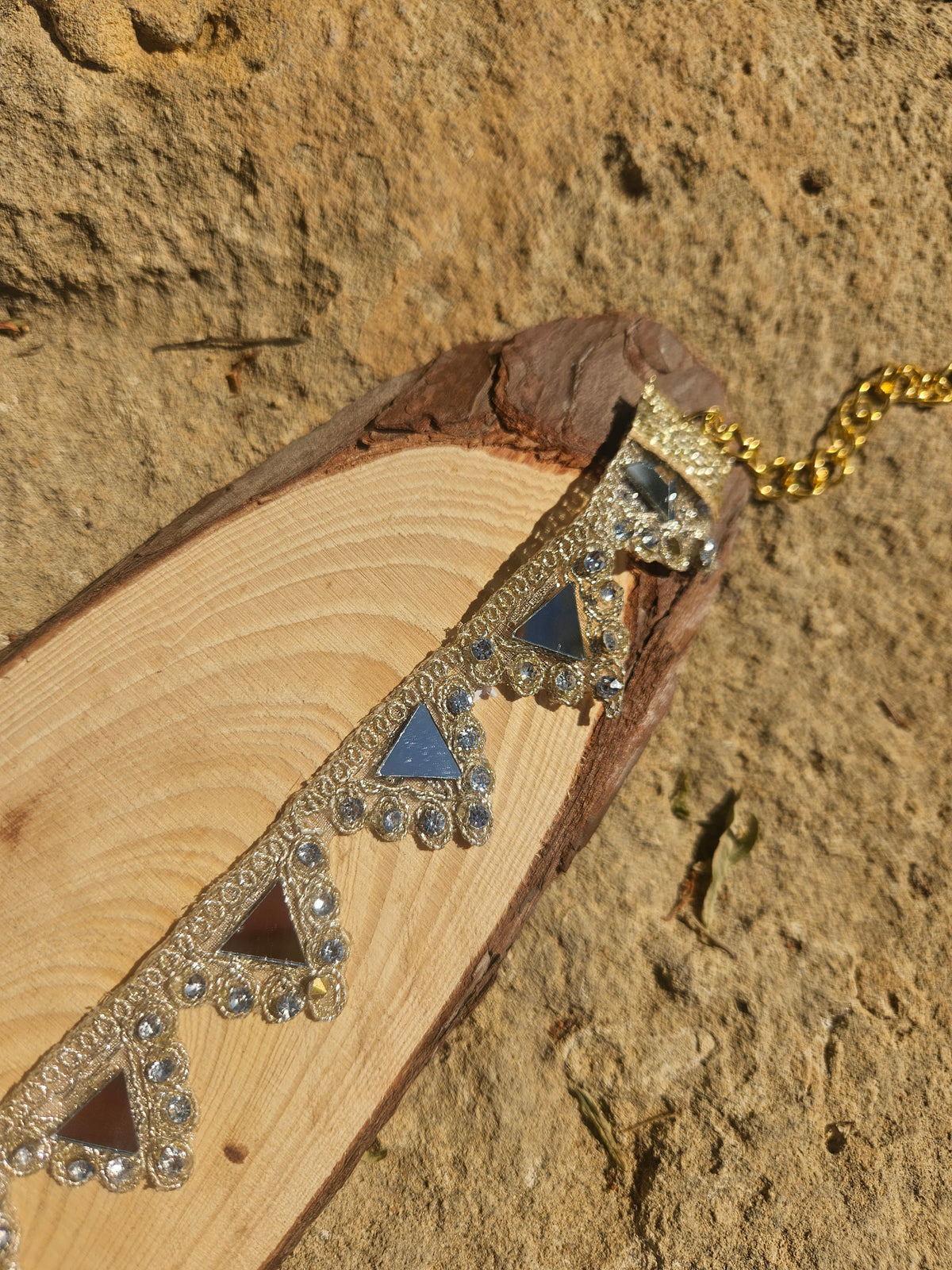 Gargantilla con detalles triangulares en azul y dorado, vista lateral