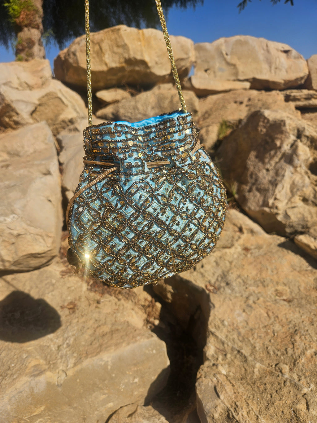 Bolso de saco bordado con lentejuelas doradas y turquesa, asa de cadena.