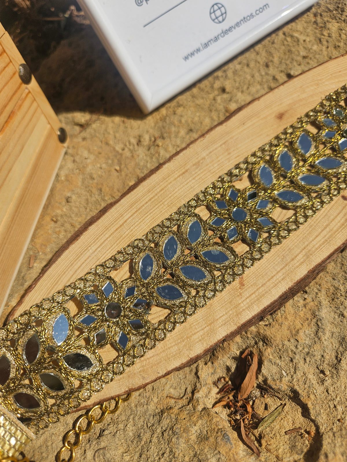 Gargantilla dorada con bordado calado y piedras azules ovaladas, con cadena decorativa