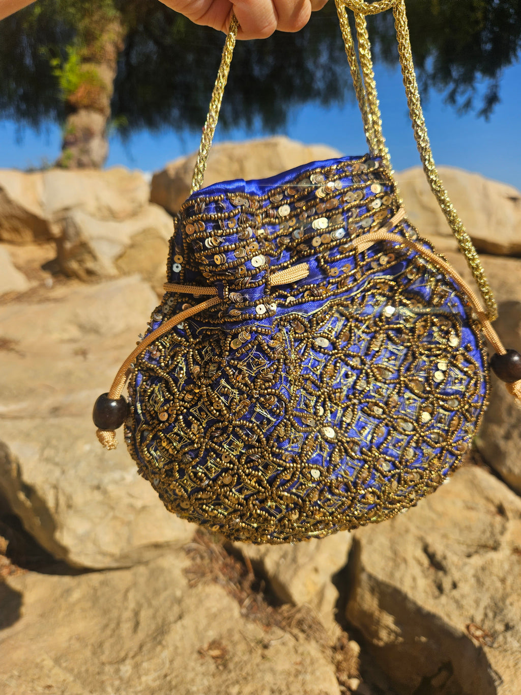 Bolso redondo bordado azul y dorado con asa de cadena y abalorios colgantes