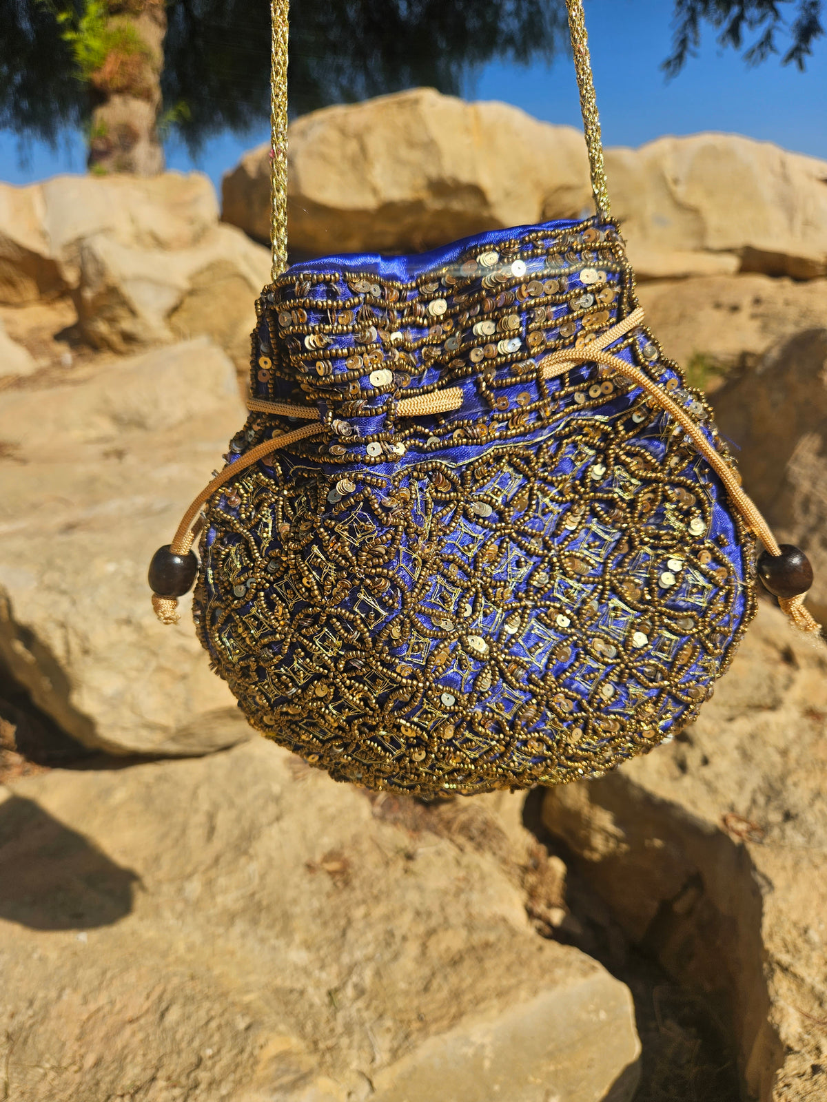 Bolso redondo bordado azul y dorado con asa de cadena y borlas de cuentas
