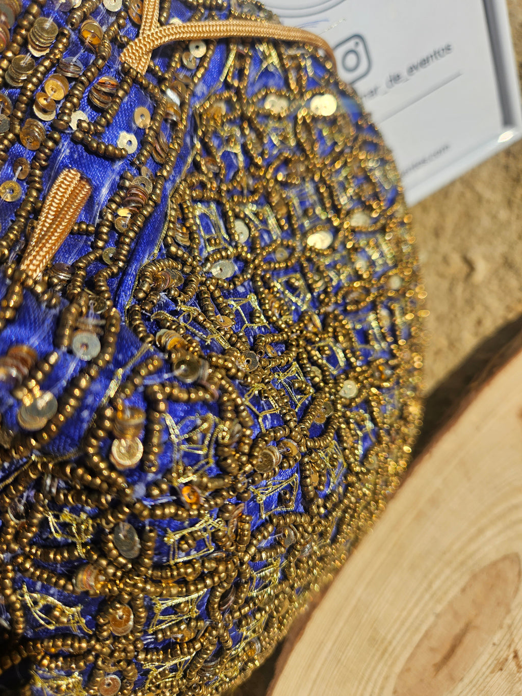 Bolso redondo bordado con cuentas y lentejuelas azul y dorado, vista en detalle.