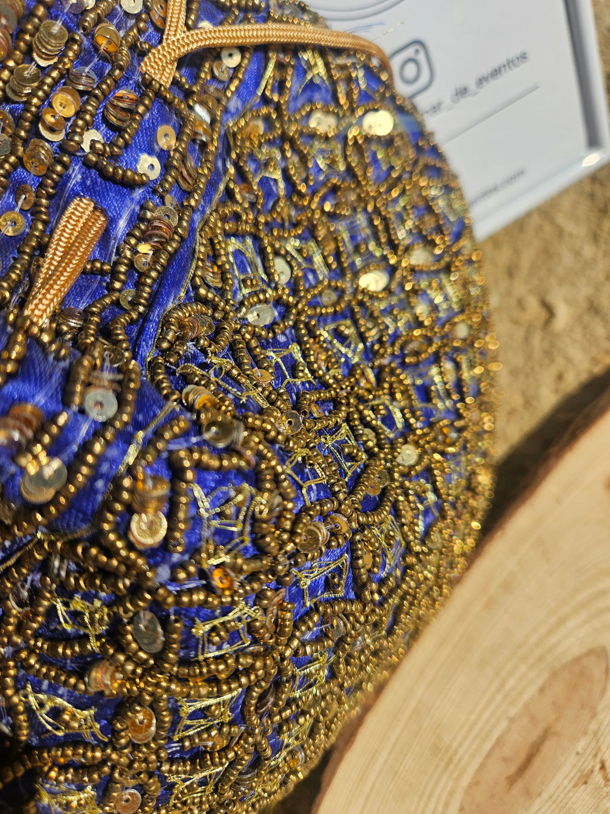 Bolso redondo bordado con cuentas y lentejuelas azul y dorado, vista en detalle.