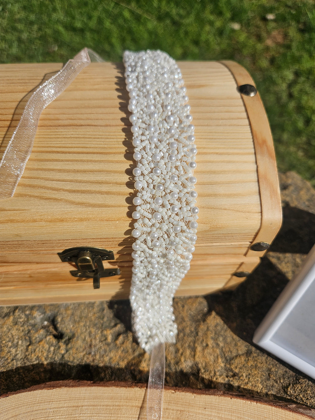 Choker de cuentas blancas, vista de perfil, con cinta transparente en la parte trasera