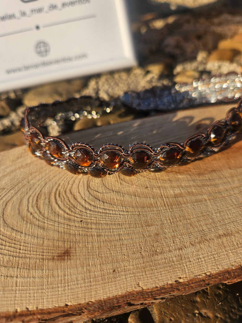 Choker de cuentas ovaladas ámbar con engarce oscuro, vista lateral sobre madera.