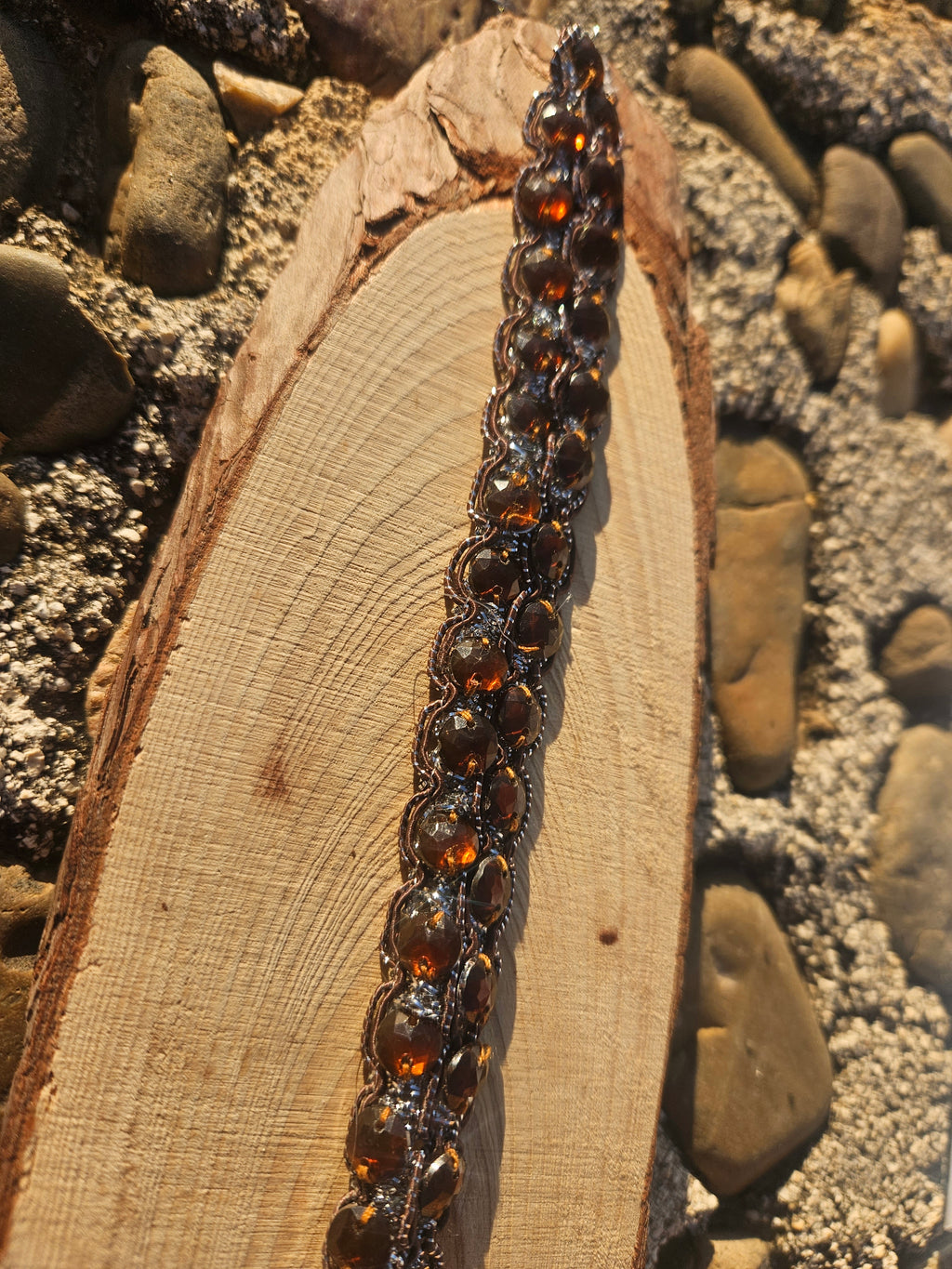Choker con cuentas ovaladas ámbar y engarces oscuros, primer plano de la fila.