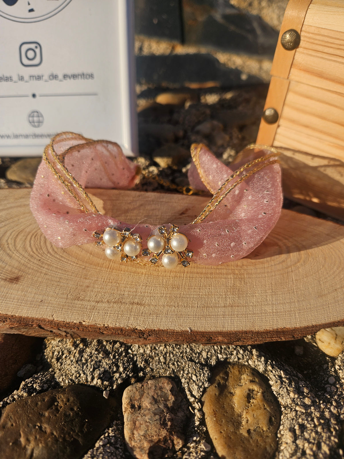 Choker rosa de tul con lazo y pedrería; banda con cuentas tipo perla central.