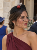 Sombrero casquete negro con velo de malla y adorno rojo y flor plateada