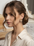 Pendientes florales con perla y cristales, llevados en la oreja