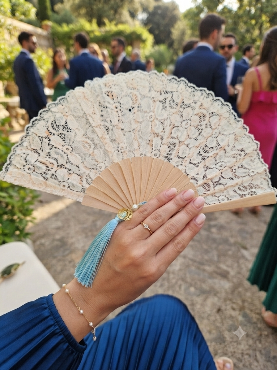 Abanico de encaje blanco y varillas de madera con borla turquesa, sostenido