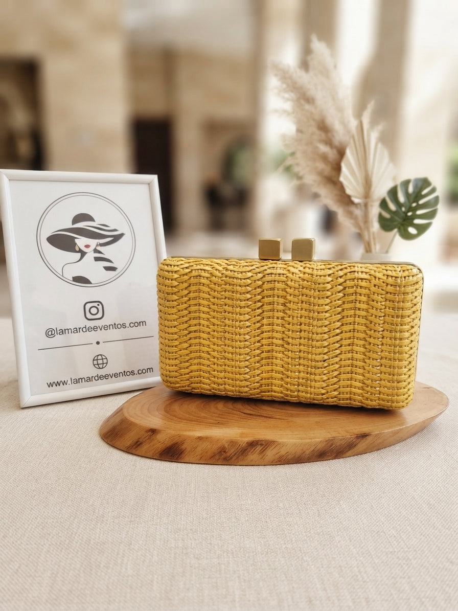 Clutch Bolso Miami de tejido trenzado amarillo rectangular con cierre metálico dorado.