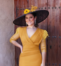 Pamela Maral, sombrero negro de ala ancha con flores amarillas y detalles