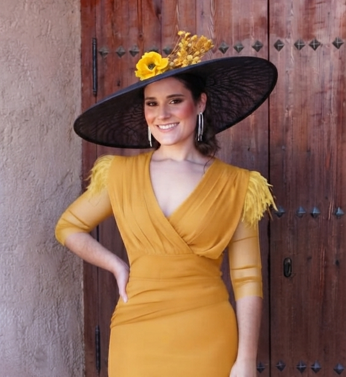 Pamela Maral, sombrero negro de ala ancha con flores amarillas y detalles