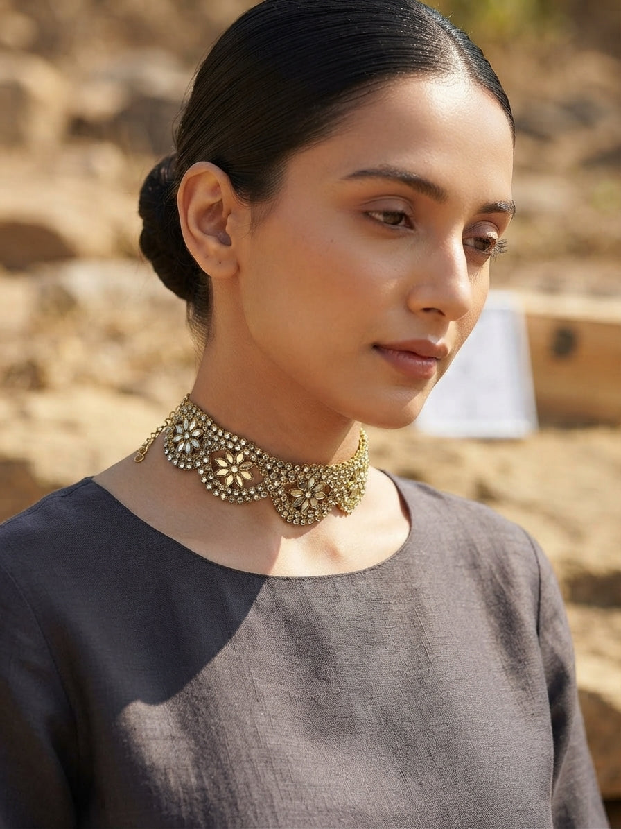 Gargantilla choker dorada con pedrería azul y motivos florales, puesta