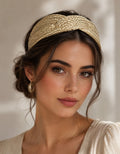 Diadema dorada ancha con textura tejida, sobre el cabello