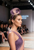 Tocado morado en la cabeza con malla beige y adorno dorado, estilo desfile
